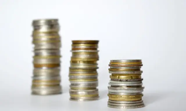 Trzy stosy monet, od najwyższego do najniższego, symbolizują wzrost kapitału. Co to towarzystwo funduszy inwestycyjnych?