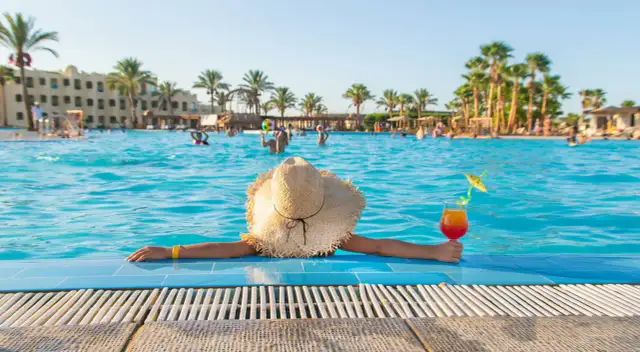 Idealne miejsce, gdzie na wakacje w maju: basen, palmy i drink. Relaks w słońcu.