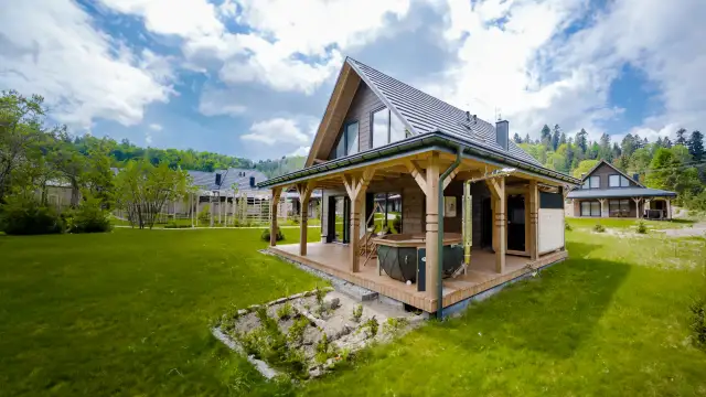 Drewniany domek z tarasem i jacuzzi w otoczeniu zieleni, Bieszczady.