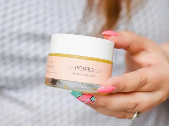 Dłoń trzymająca słoiczek z serum rewitalizującym myPOWERelixir.