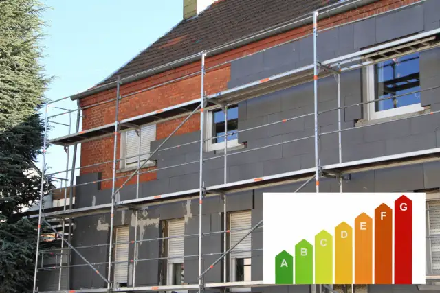 Dom w trakcie ocieplenia domów. Scaffolding otacza budynek, na którym montowane są płyty izolacyjne. W rogu wstawka z klasą energetyczną.