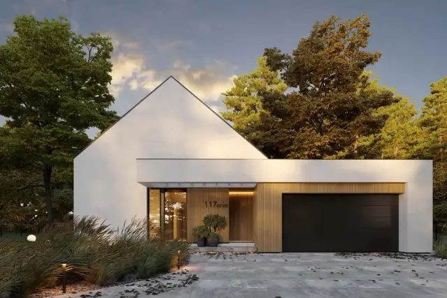 Nowoczesny dom w kształcie litery L, z białymi ścianami, drewnianymi elementami i czarną bramą garażową, otoczony drzewami.
