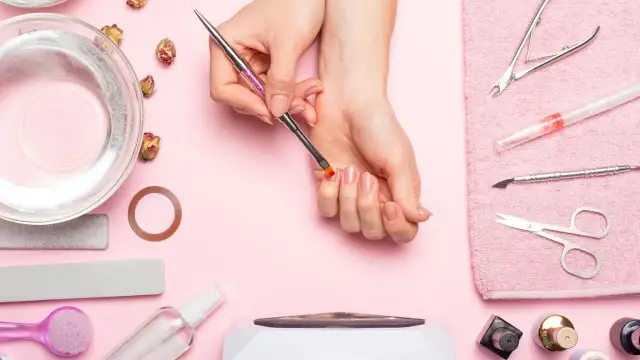 Narzędzia do manicure i dłonie przygotowujące się do zabiegu. Dowiedz się, jak odkleić tipsy i uzyskać idealne paznokcie.