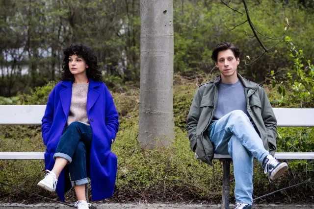 Para z serialu "Kiedy ślub" siedzi na ławce w parku, oddzielona drzewem.