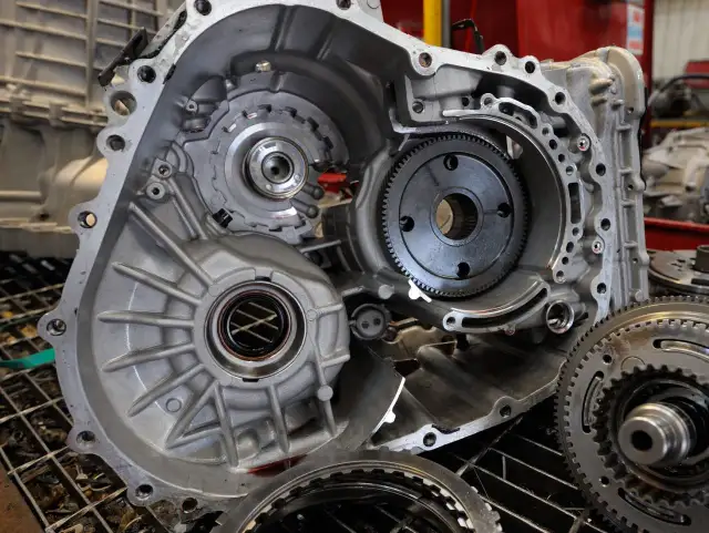 Rozłożona skrzynia biegów, widoczne koła zębate i elementy. Może to być związane z uszkodzony wybierak skrzyni biegów objawy.