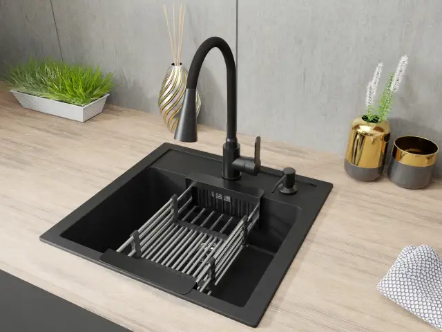 Czarny zlew Franke z baterią i suszarką na naczynia na drewnianym blacie.