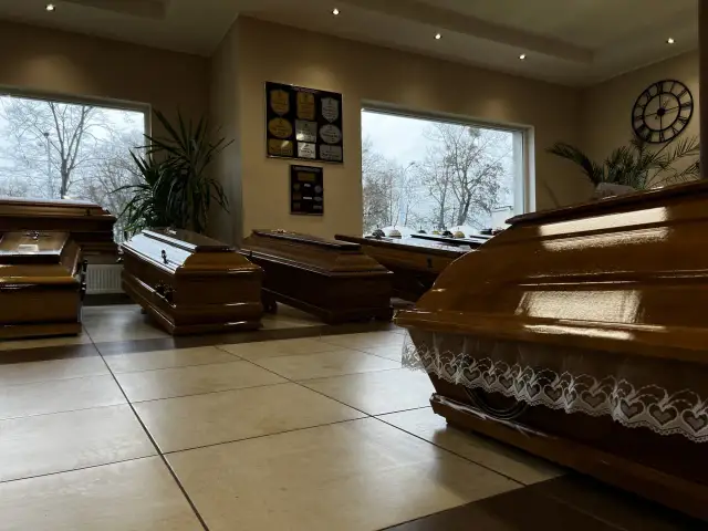Wnętrze zakładu pogrzebowego z kilkoma drewnianymi trumnami.