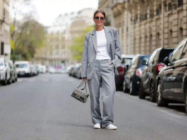 Elegancka stylizacja smart casual damski lato: szary garnitur, biały top, sneakersy i torebka Fendi.