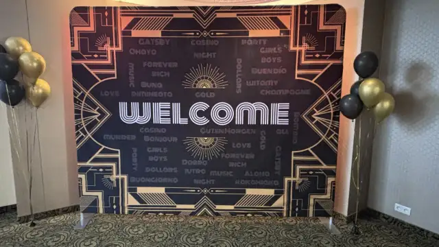 Tło w stylu lat 20. z napisem "WELCOME" i złotymi balonami.