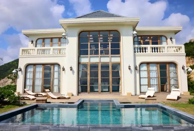 Luksusowy hotel paradise 8 z basenem i leżakami, otoczony zielenią i górami.