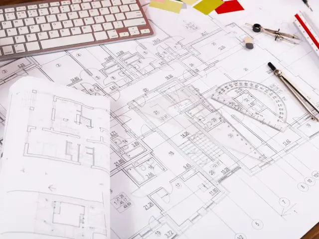 Rzut pokoju z widocznym planem architektonicznym, klawiaturą, cyrklem i linijką.