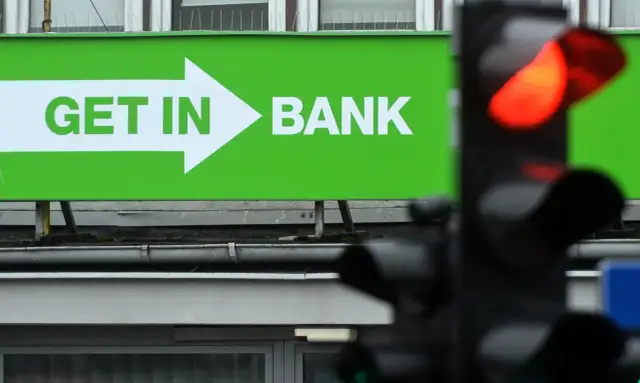 Zielony baner z napisem "GET IN BANK" i strzałką. Zastanawiasz się, co z lokatami w Getin Banku?