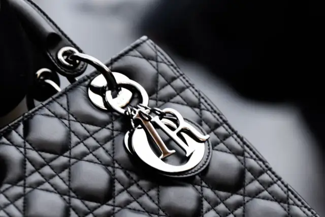 Elegancka, pikowana torebka Lady Dior w kolorze czarnym, z metalicznym logo Dior.