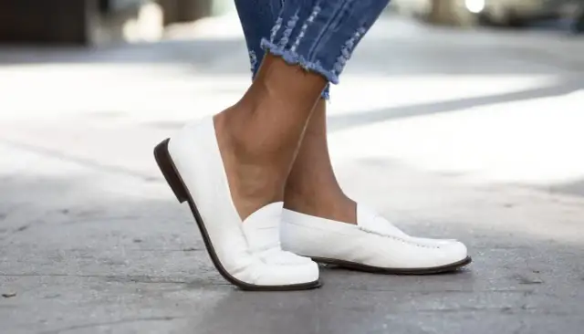 Białe mokasyny damskie w stylizacjach z jeansami z postrzępionymi nogawkami. Klasyka i wygoda na co dzień.