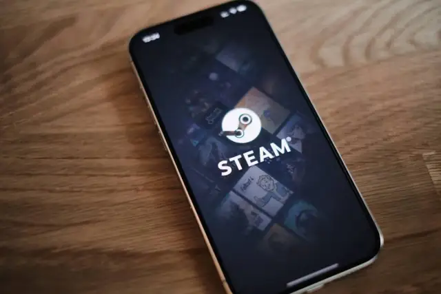 Telefon z otwartą aplikacją Steam i widocznym logo platformy.