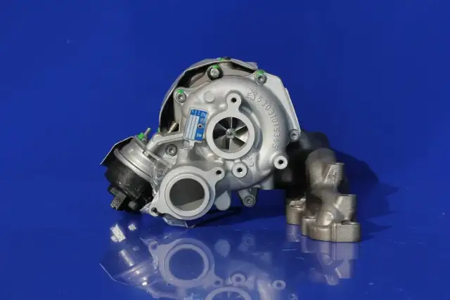 Turbosprężarka samochodowa z widocznym zaworem upustowym na niebieskim tle.