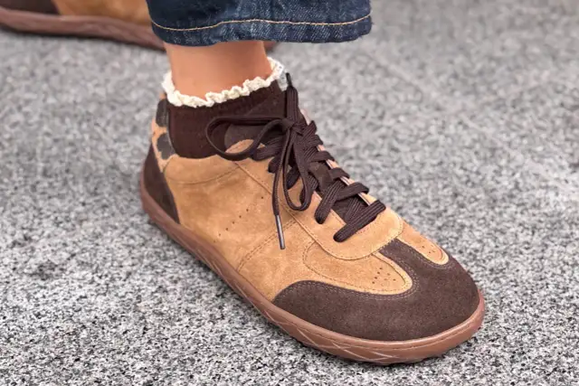 Brązowe buty sportowe z zamszu z koronkowym wykończeniem skarpetki.