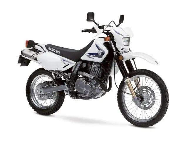 Biały motocykl Suzuki DR650SE, idealny na lekkie enduro turystyczne, gotowy na przygodę.