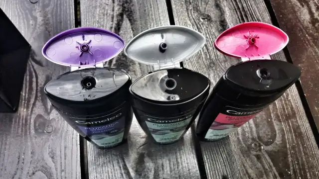 Trzy butelki płukanki do włosów Cameleo z otwartymi, kolorowymi nakrętkami. Dowiedz się, jak stosować płukankę do włosów Cameleo dla pięknego koloru.