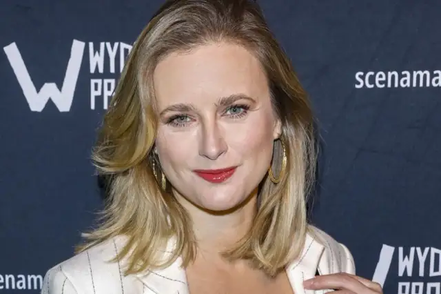 Marta Chodorowska, z uśmiechem i w złotej biżuterii, wygląda jakby opowiadała o swoich dzieciach.