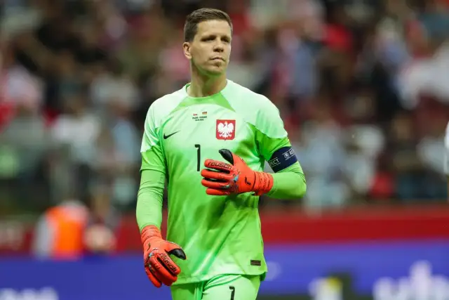 Wojciech Szczęsny, bramkarz reprezentacji Polski, w zielonej koszulce i pomarańczowych rękawicach. Jego imponujący wzrost pozwala mu skutecznie bronić.