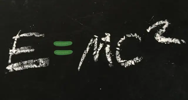 Równanie E=mc² napisane kredą na czarnej tablicy.