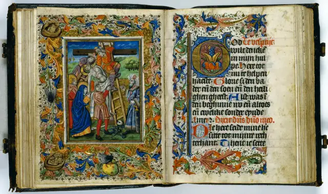 Otwarta księga średniowieczna z ilustracją Ukrzyżowania i ozdobnym tekstem.