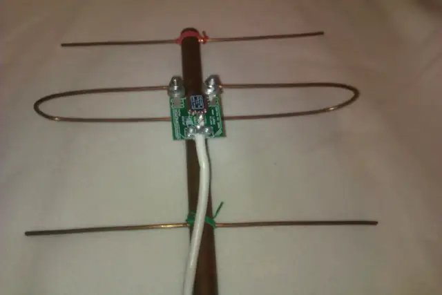 Domowa antena TV z miedzianych drutów, płytką drukowaną i białym kablem.