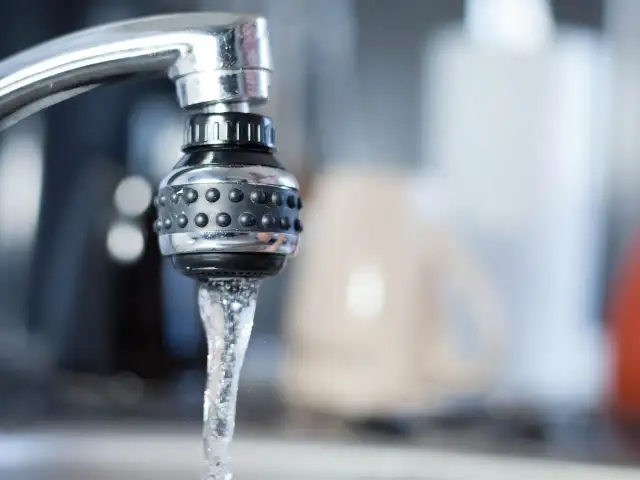 Strumień wody wypływający z kranu z perlator.