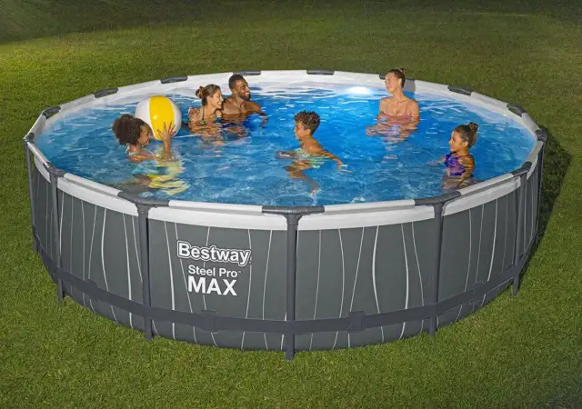 Rodzina pluska się w okrągłym basenie naziemnym Bestway Steel Pro MAX na trawniku.