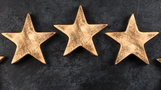 Trzy złote gwiazdki na ciemnym tle. Symbolizują moment, kiedy hotel dostaje gwiazdki, nagrodę za jakość.
