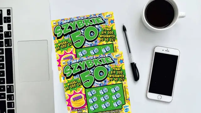 Dwie zdrapki "Szybkie 50" leżą obok laptopa, telefonu i kawy. Czyżby zdrapka jest wygrana?