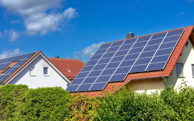 Domy z panelami fotowoltaicznymi na dachach. Zastanawiasz się, ile waży panel fotowoltaiczny? To zależy od jego wielkości i materiałów.