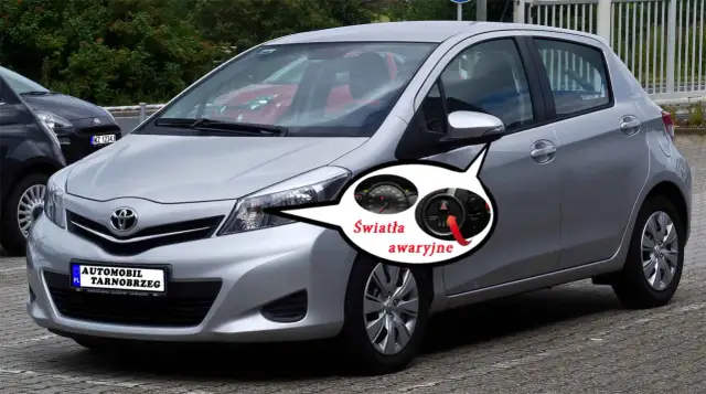 Srebrny Toyota Yaris z zaznaczonymi światłami awaryjnymi. Pod maską kryje się silnik, ale to kontrolki na desce rozdzielczej informują o problemach.