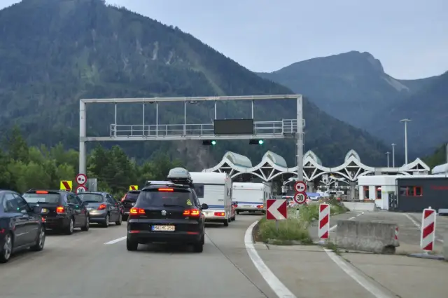 Korki na autostradzie przed punktem poboru opłat z widokiem na góry.