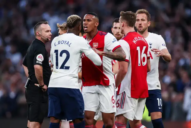 Piłkarze Arsenalu i Tottenhamu w gorącej dyskusji z sędzią. To właśnie co to są derby w piłce nożnej – mecze pełne emocji i napięcia.