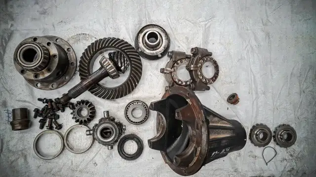 Rozłożony dyferencjał BMW E39 z częściami: koła zębate, łożyska, obudowa.