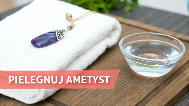 Ametyst, kamień urodzeniowy Ryb, leży na białym ręczniku obok miseczki z wodą.