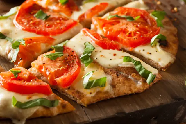 Pyszna pizza margherita z pomidorami i mozzarellą, idealna na bezglutenowy przepis.