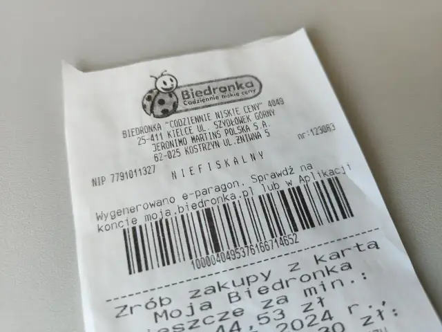 Jak wygląda faktura z Biedronki: paragon z logo biedronki, danymi sklepu, kodem kreskowym i informacją o e-paragonie.