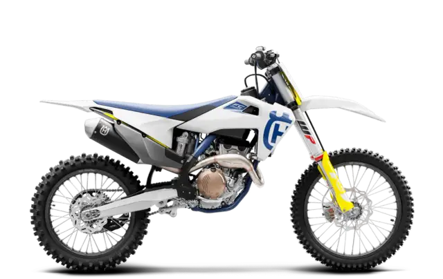 Biały motocykl Husqvarna FC 250 z niebieskim siedzeniem i żółtymi akcentami, gotowy do jazdy po torze.