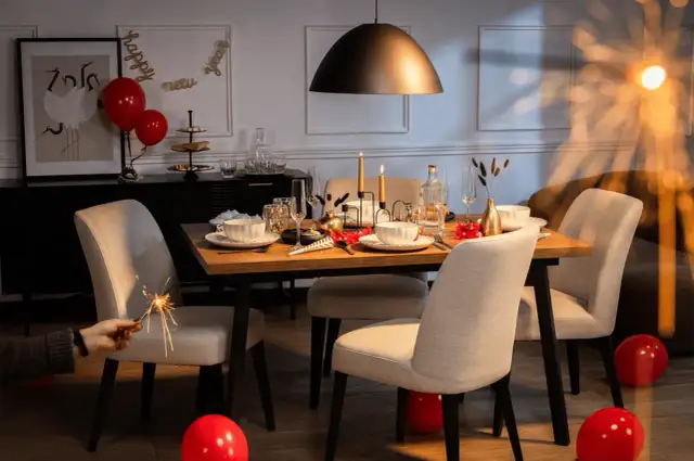 Stół nakryty do kolacji, świece, balony i sztuczne ognie tworzą atmosferę imprezy w stylu lat 70.