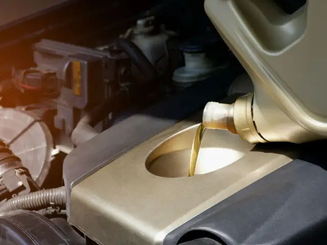 Wlewanie oleju silnikowego do silnika samochodu.