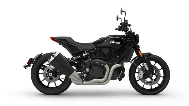 Czarny motocykl Indian FTR 1200 z charakterystycznym logo Indian na baku. Widok z boku na jego sportową sylwetkę i podwójny wydech.
