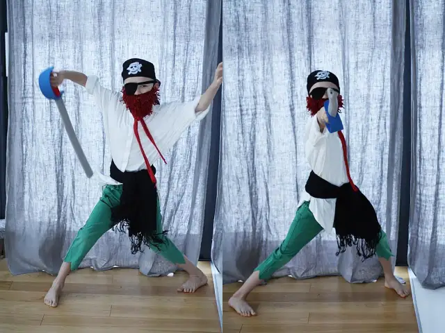 Chłopiec w stroju pirata z czarną opaską na oku, czerwoną brodą i mieczem.