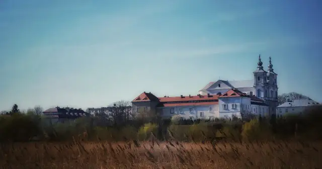 Krasnystaw: zespół klasztorny z wieżami kościoła na tle błękitnego nieba.