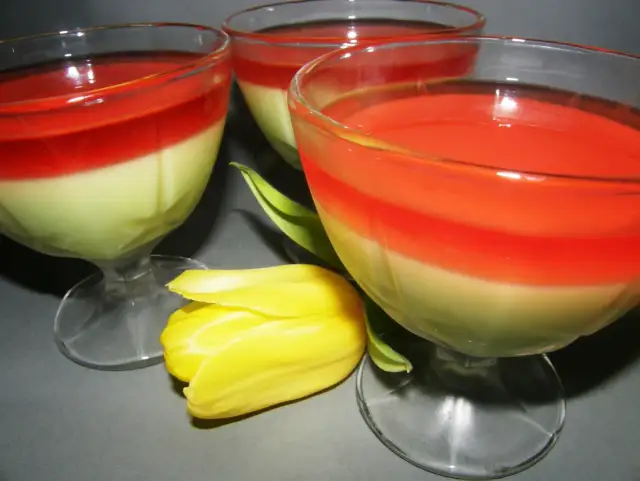 Trzy pucharki z dwuwarstwowym galaretkowcem z serków homogenizowanych, ozdobione żółtym tulipanem.