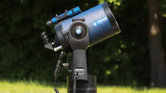 Niebieski teleskop Meade LX90 ACF na montażu, na tle zieleni.