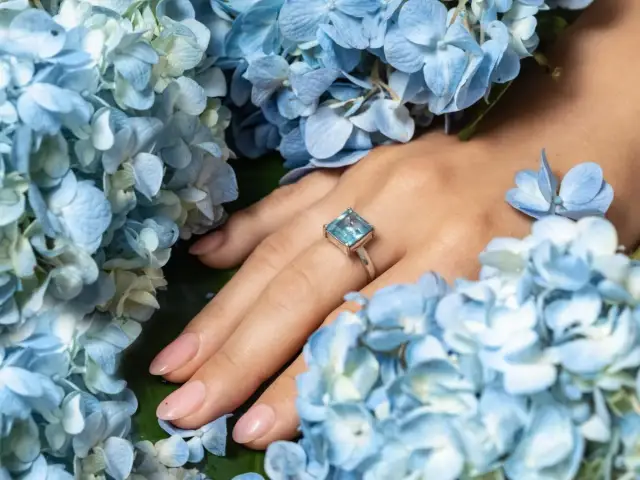 Błękitne hortensje otulają dłoń z pierścionkiem z akwamarynem. Idealny prezent na 16 rocznicę ślubu.