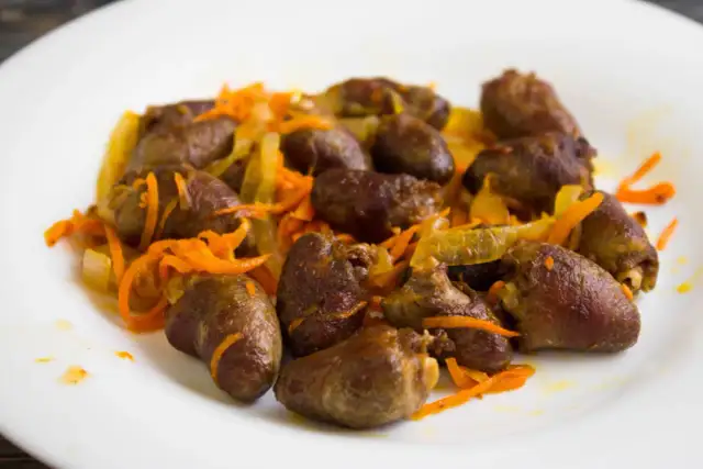 Duszona marchewka z cebulką i sercami drobiowymi. Czy żołądki z kurczaka są zdrowe? Tak, to bogate źródło białka i żelaza.